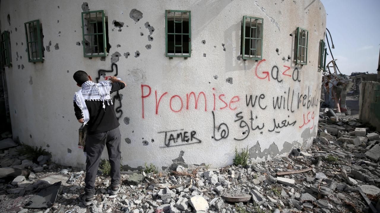Gazzeli Tamer, duvarlara “yeniden inşa edeceğiz” yazıyor