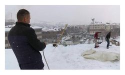 Ekmeklerini karlı çatılardan çıkarıyorlar