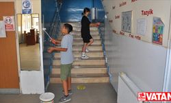 Müdür ve gönüllü öğrenciler okullarını boyuyor