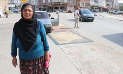 Tozdan rahatsız olan kadın yoldaki çukurları halıyla kapattı