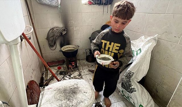 Gazze'de bir hastaneye sığınan Filistinli aile, yer olmadığı için yemeklerini banyoda pişiriyor